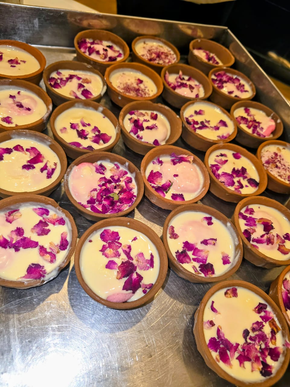 Rose-garnished desserts served in earthen bowls